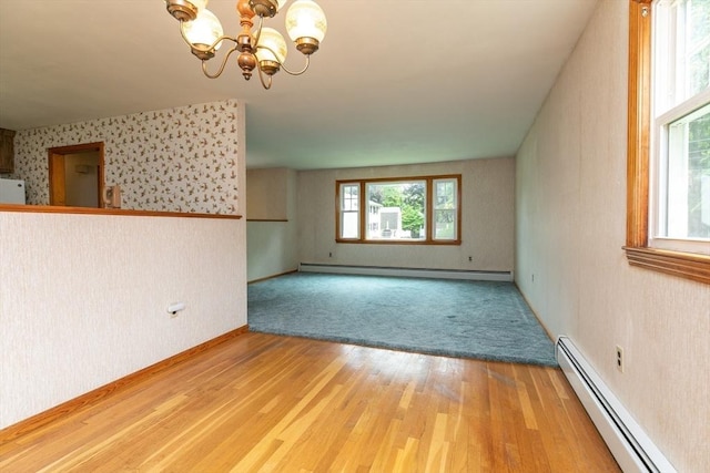 4 Morningside Dr, Beverly, MA 01915 - empty room with baseboard heating, a chandelier, wood finished floors, and wallpapered walls