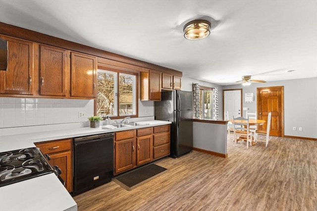 kitchen with light wood-type flooring, light countertops, and black appliances