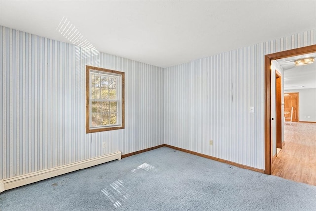 empty room featuring carpet floors, baseboards, baseboard heating, and wallpapered walls