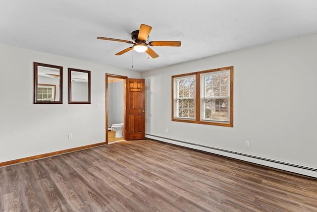 empty room with baseboards, a baseboard heating unit, ceiling fan, and wood finished floors