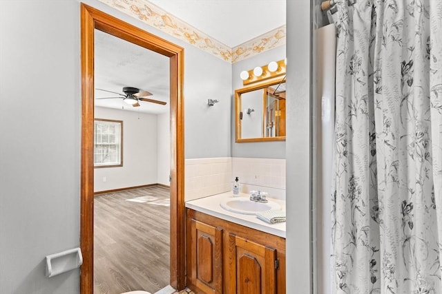 full bathroom with ceiling fan, wood finished floors, vanity, baseboards, and a shower with curtain