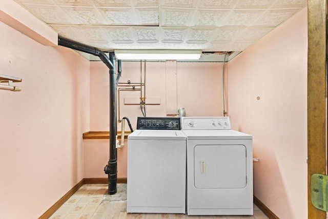 laundry room with laundry area, separate washer and dryer, and baseboards