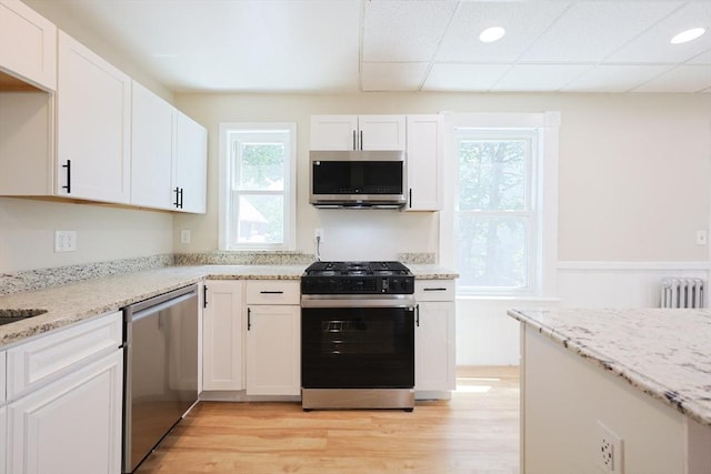 20-22 Ashland Ave, Methuen, MA 01844 - kitchen featuring appliances with stainless steel finishes, radiator, plenty of natural light, light wood-style flooring, and a wainscoted wall