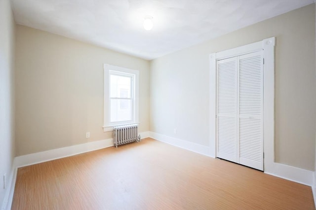 20-22 Ashland Ave, Methuen, MA 01844 - unfurnished bedroom featuring radiator heating unit, a closet, wood finished floors, and baseboards