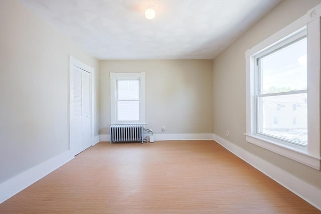 20-22 Ashland Ave, Methuen, MA 01844 - unfurnished room with radiator heating unit, healthy amount of natural light, baseboards, and light wood-style flooring