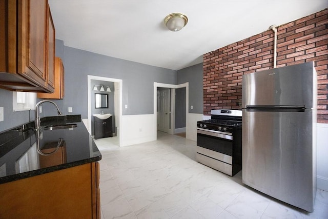 20-22 Ashland Ave, Methuen, MA 01844 - kitchen featuring appliances with stainless steel finishes, brown cabinetry, a sink, dark stone countertops, and a wainscoted wall