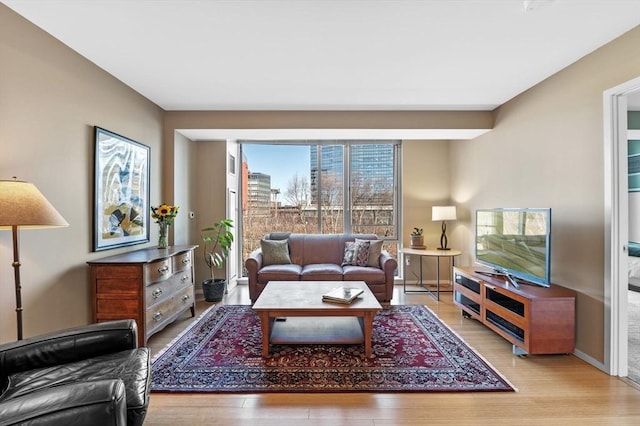 living area featuring light wood-style flooring and baseboards