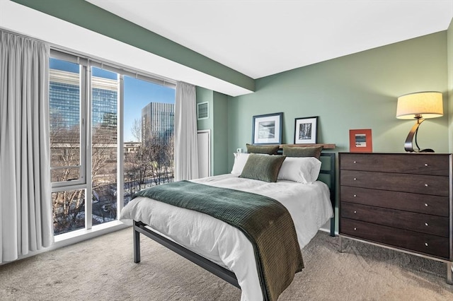 carpeted bedroom featuring visible vents and a city view