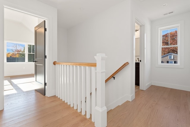 hall featuring lofted ceiling and light hardwood / wood-style floors