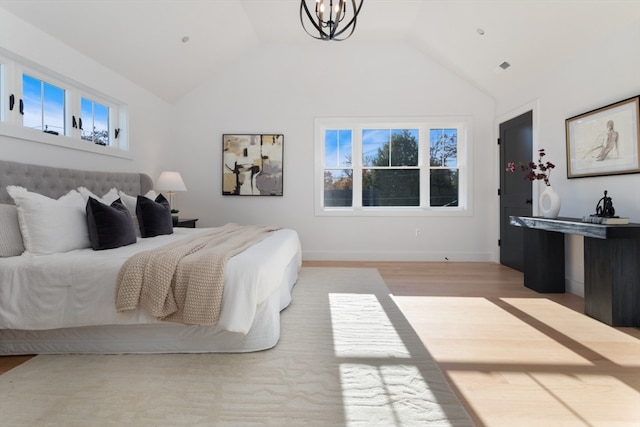 bedroom with vaulted ceiling, light wood-type flooring, and an inviting chandelier