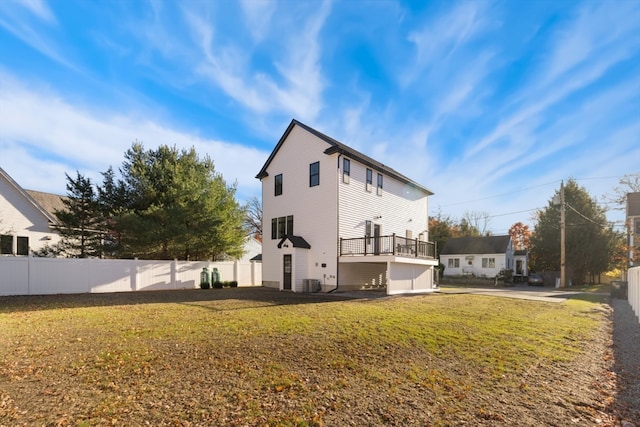 back of property with a yard, a deck, and central AC unit