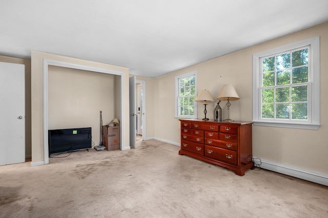 interior space featuring a baseboard radiator, multiple windows, and carpet