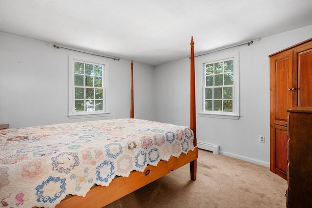 carpeted bedroom with multiple windows and a baseboard heating unit