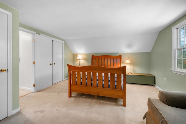 bedroom featuring lofted ceiling and light colored carpet