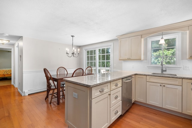 kitchen with kitchen peninsula, light hardwood / wood-style flooring, hanging light fixtures, and a healthy amount of sunlight