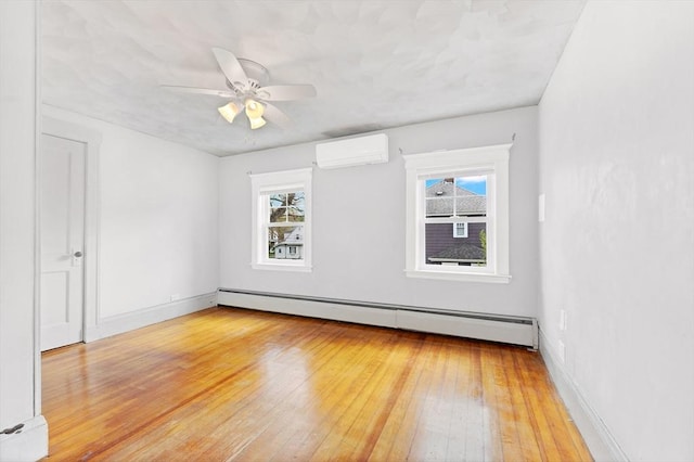 unfurnished room with a wall mounted air conditioner, baseboard heating, light wood-style flooring, a baseboard heating unit, and a ceiling fan