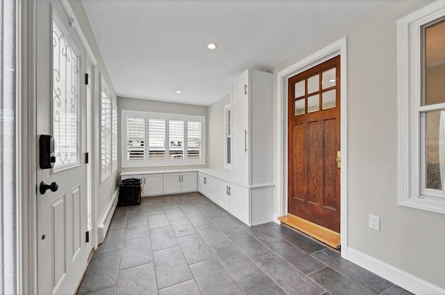 foyer with baseboard heating, baseboards, recessed lighting, and dark tile patterned floors