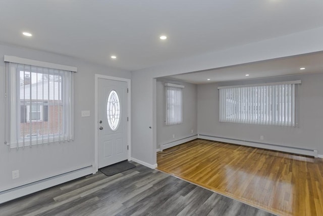 entrance foyer featuring a baseboard heating unit, wood finished floors, and recessed lighting