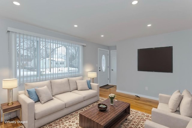 living room featuring baseboards, light wood-style flooring, and recessed lighting