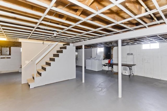 below grade area featuring electric panel, stairway, and separate washer and dryer