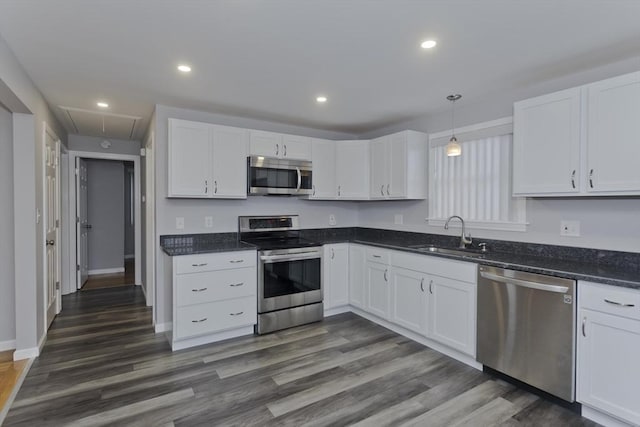 kitchen featuring appliances with stainless steel finishes, dark wood-style flooring, a sink, and white cabinetry