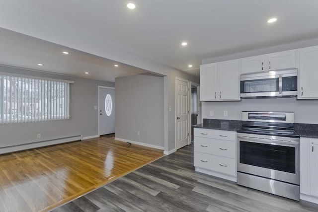 kitchen with appliances with stainless steel finishes, wood finished floors, white cabinetry, and recessed lighting