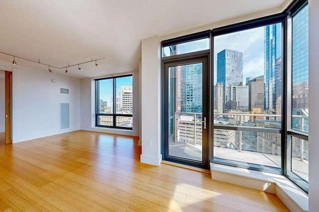 45 Province St Unit U1602, Boston, MA 02108 - empty room featuring rail lighting, wood finished floors, a city view, and healthy amount of natural light