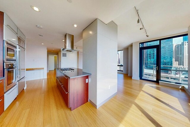 45 Province St Unit U1602, Boston, MA 02108 - kitchen featuring modern cabinets, built in appliances, light wood-style floors, island range hood, and a wall of windows