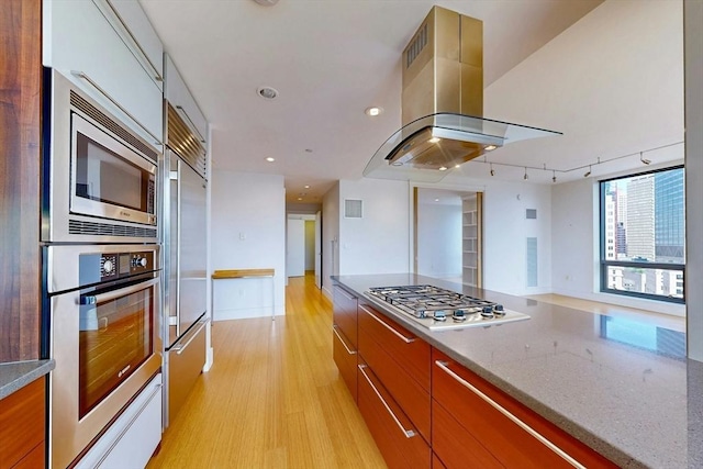 45 Province St Unit U1602, Boston, MA 02108 - kitchen featuring built in appliances, island exhaust hood, modern cabinets, light wood-type flooring, and track lighting
