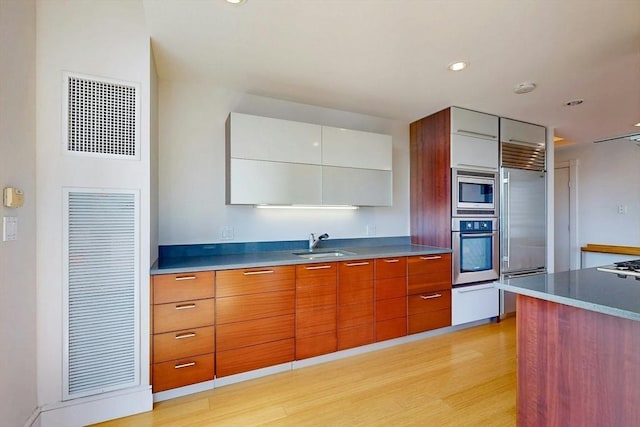 45 Province St Unit U1602, Boston, MA 02108 - kitchen featuring built in appliances, modern cabinets, a sink, light wood-style floors, and brown cabinets