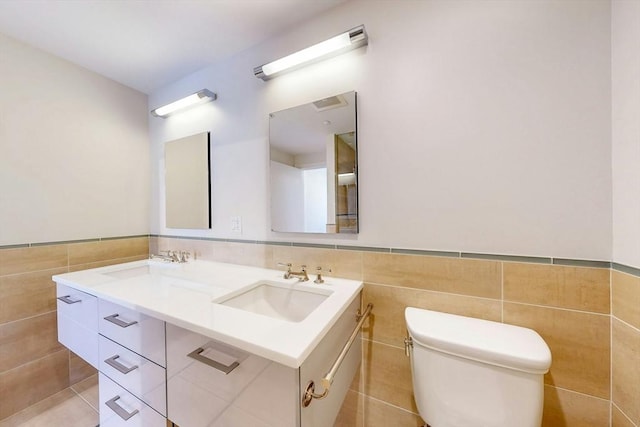 45 Province St Unit U1602, Boston, MA 02108 - full bathroom with tile walls, double vanity, toilet, wainscoting, and tile patterned floors