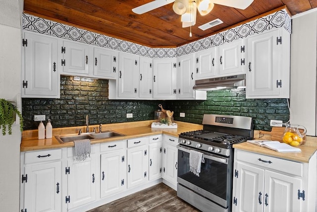 kitchen with stainless steel gas range oven, a sink, white cabinets, and under cabinet range hood