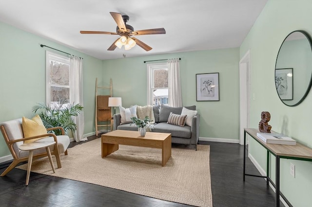 sitting room featuring plenty of natural light, baseboards, and dark wood finished floors