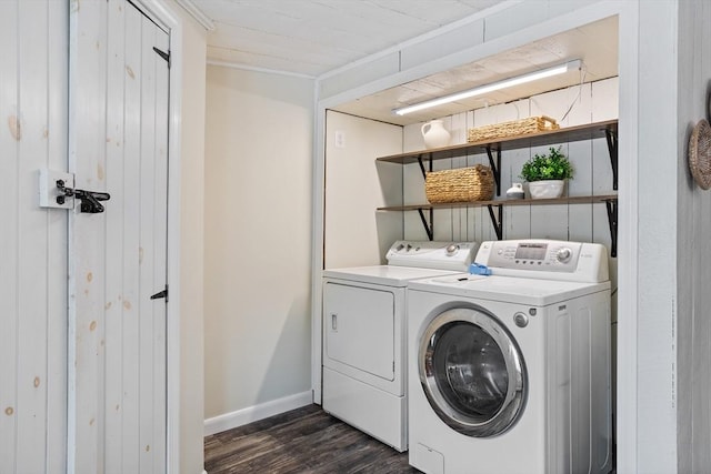 clothes washing area featuring laundry area, baseboards, dark wood finished floors, and washer and dryer