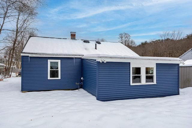 snow covered house with a chimney