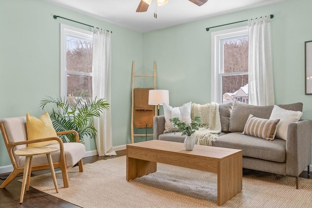 sitting room featuring baseboards, a ceiling fan, and wood finished floors