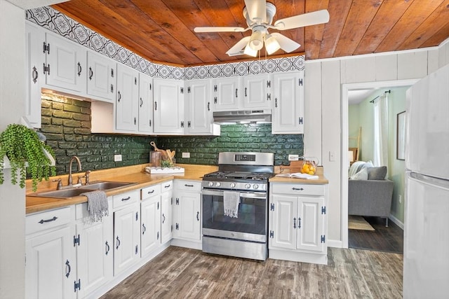 kitchen with gas range, under cabinet range hood, white cabinetry, and light countertops