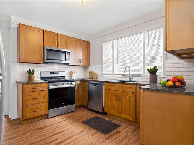 9-11 Edmunds St, Cambridge, MA 02140 - kitchen featuring appliances with stainless steel finishes, a sink, backsplash, light wood-type flooring, and brown cabinetry