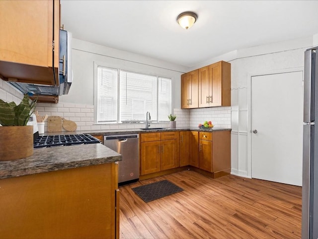 9-11 Edmunds St, Cambridge, MA 02140 - kitchen with stainless steel appliances, light wood-type flooring, a sink, dark countertops, and backsplash