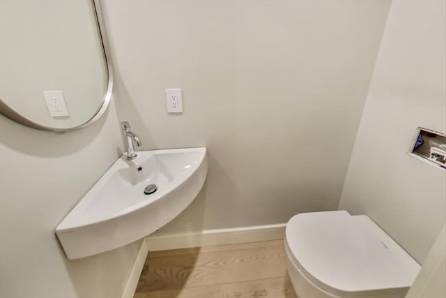 bathroom with toilet and wood-type flooring