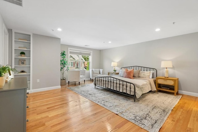 bedroom with light wood-style floors, baseboards, and recessed lighting