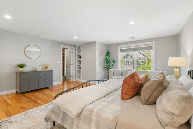 bedroom featuring wood finished floors, baseboards, recessed lighting, and a spacious closet