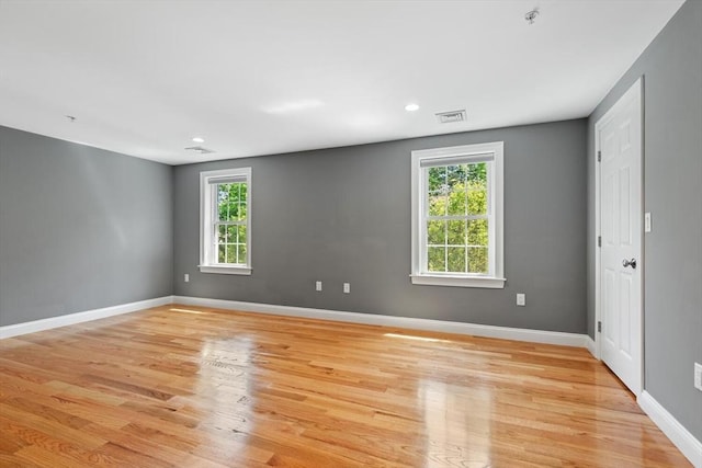 empty room with light wood-style flooring, a pendent fire sprinkler, baseboards, and recessed lighting