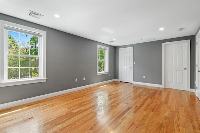 empty room featuring healthy amount of natural light, light wood-style floors, baseboards, and recessed lighting