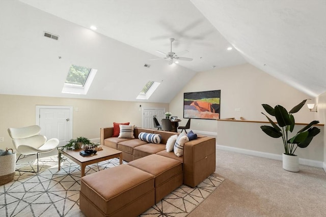 living room featuring a skylight, lofted ceiling, light colored carpet, baseboards, and ceiling fan