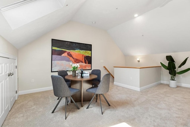dining room with carpet, lofted ceiling, baseboards, and a skylight