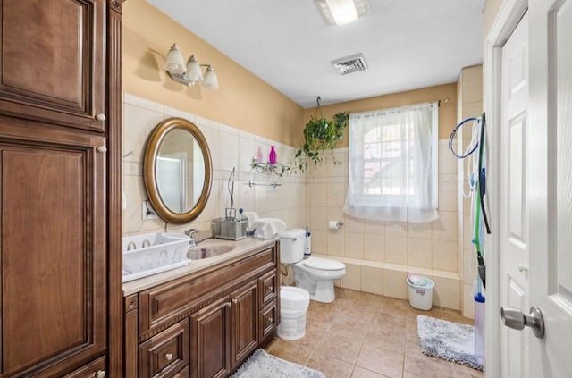 full bath featuring tile walls, toilet, tile patterned flooring, vanity, and a bathtub