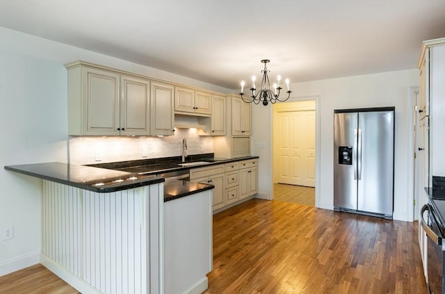14 Chandler Ln, Amherst, NH 03031 - kitchen featuring stainless steel refrigerator with ice dispenser, cream cabinets, dark countertops, and a chandelier