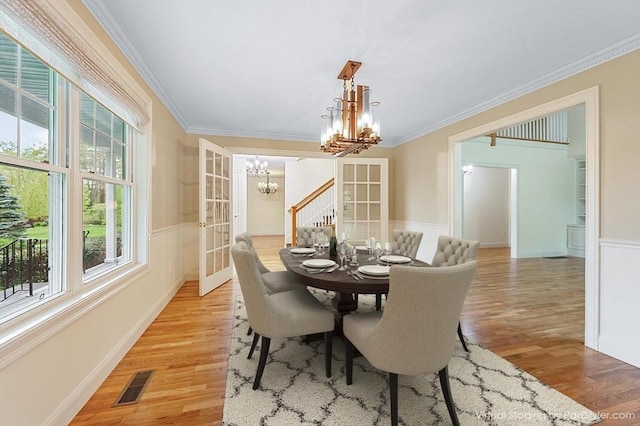 14 Chandler Ln, Amherst, NH 03031 - dining room with a chandelier, light wood finished floors, crown molding, wainscoting, and french doors