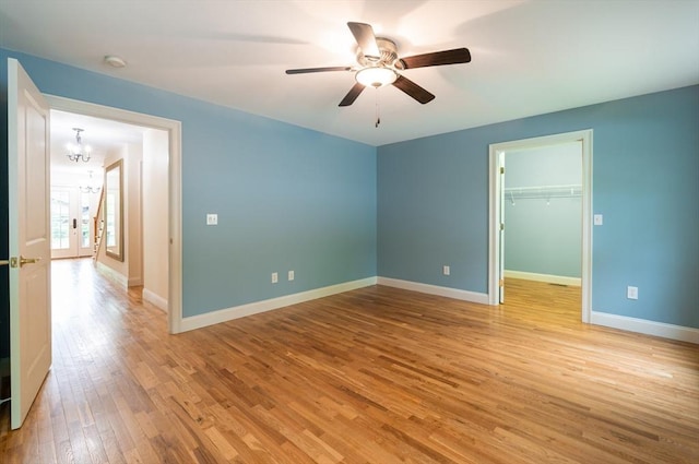 14 Chandler Ln, Amherst, NH 03031 - unfurnished bedroom featuring light wood-style flooring, a chandelier, a walk in closet, a ceiling fan, and a closet